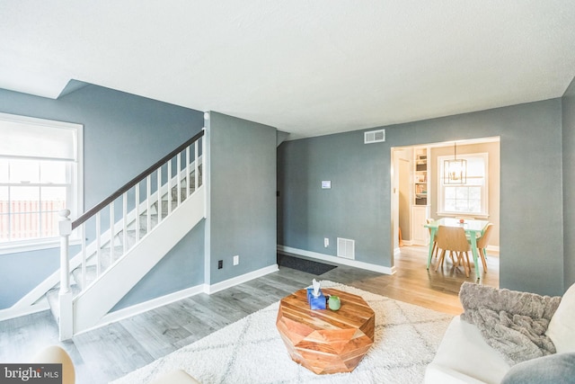 living room featuring wood-type flooring and a notable chandelier