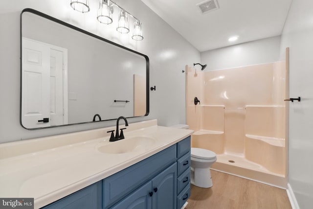 bathroom with vanity, toilet, a shower, and wood-type flooring