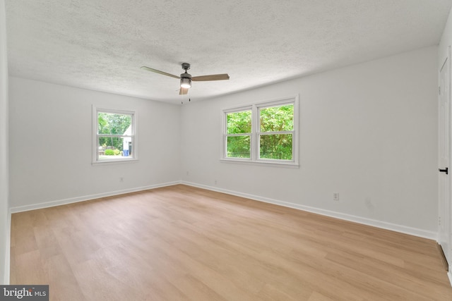 unfurnished room featuring a textured ceiling, light wood-type flooring, a wealth of natural light, and ceiling fan