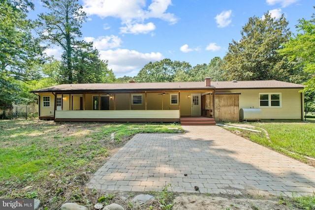 ranch-style home with covered porch and a front yard