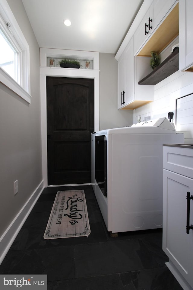 laundry area with washer and clothes dryer and cabinets