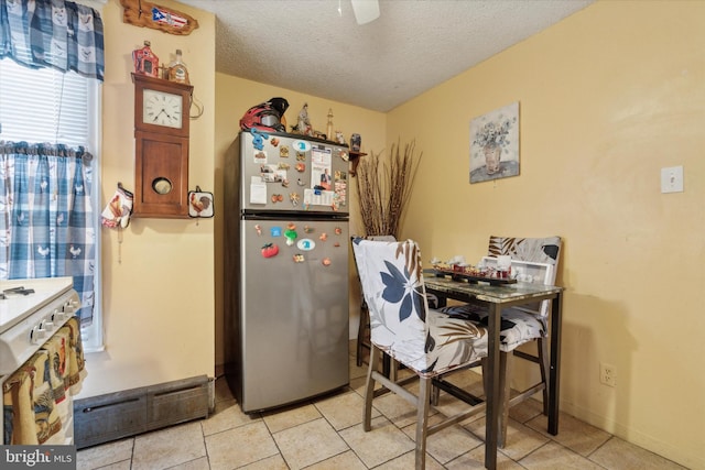 tiled dining space with a textured ceiling