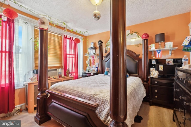 bedroom with light wood-type flooring and a textured ceiling