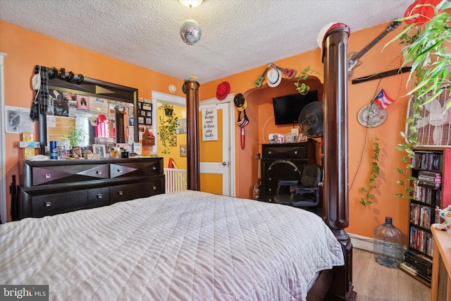 bedroom with wood-type flooring and a textured ceiling