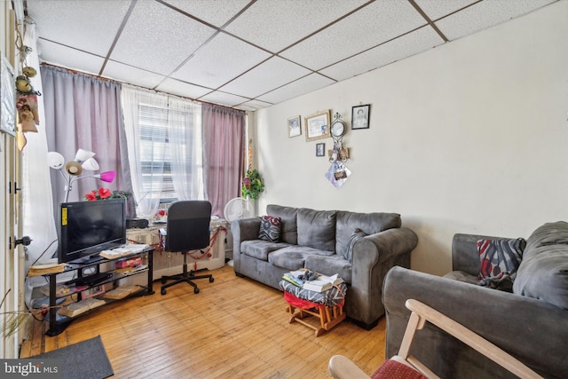 living room featuring a paneled ceiling and wood-type flooring