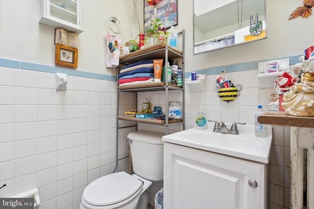 bathroom featuring tile walls, vanity, and toilet