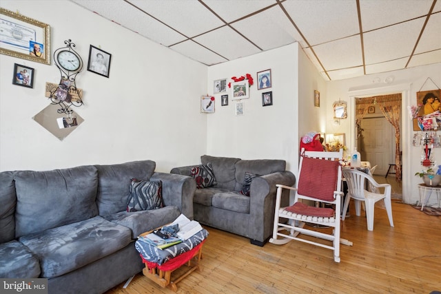 living room with wood-type flooring and a paneled ceiling