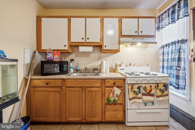 kitchen featuring white stove, white cabinets, sink, tasteful backsplash, and light tile patterned flooring