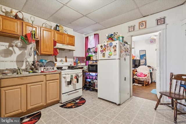 kitchen with a paneled ceiling, white appliances, sink, and light hardwood / wood-style flooring