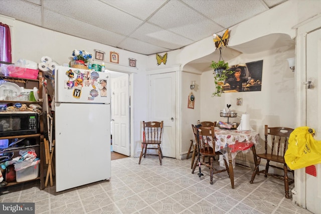 kitchen with a paneled ceiling and white fridge