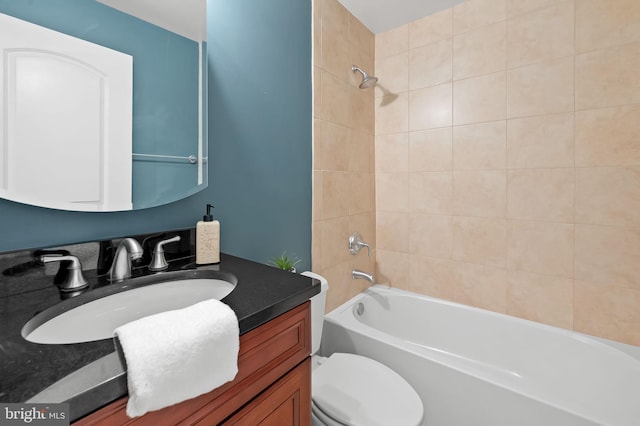 full bathroom featuring toilet, tiled shower / bath, and vanity