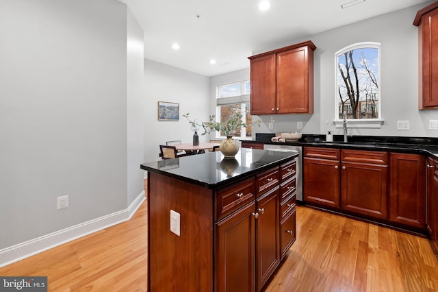 kitchen featuring sink, light wood-type flooring, and a kitchen island