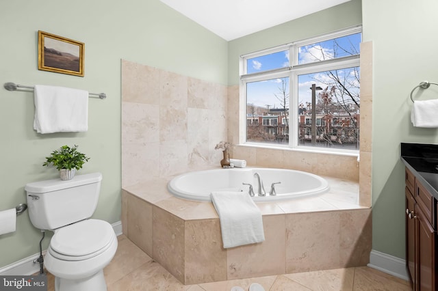 bathroom with a relaxing tiled tub, vanity, tile patterned floors, and toilet