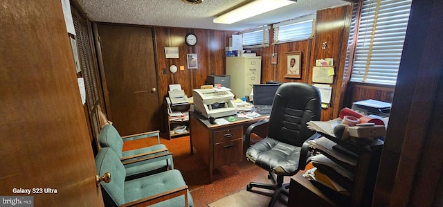 office space with a textured ceiling and wood walls