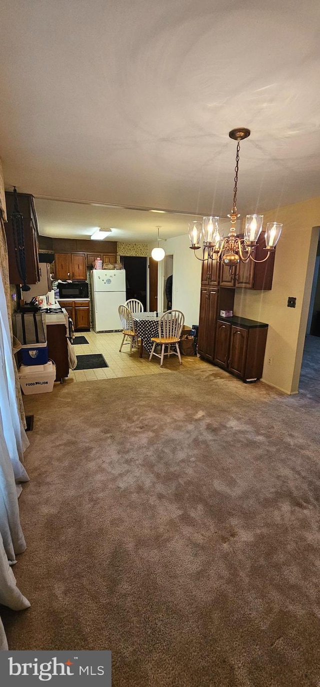 carpeted dining room featuring a chandelier