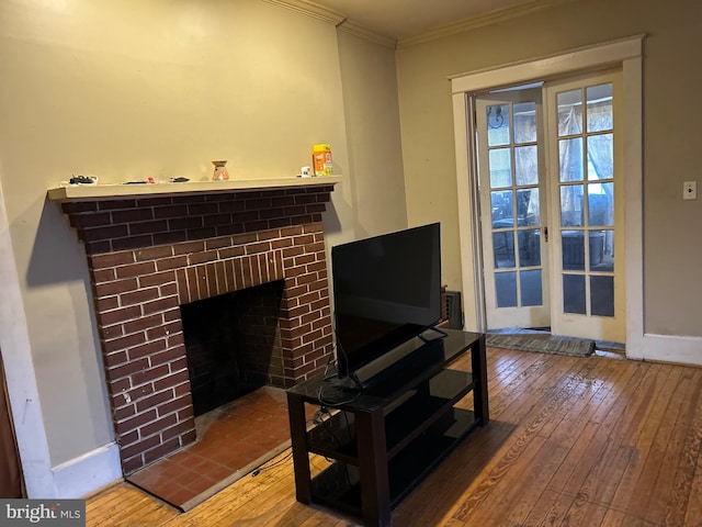 living room with a brick fireplace, hardwood / wood-style floors, and ornamental molding