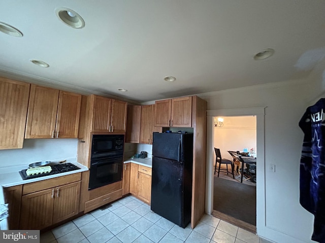 kitchen featuring light tile patterned floors, black appliances, and ornamental molding