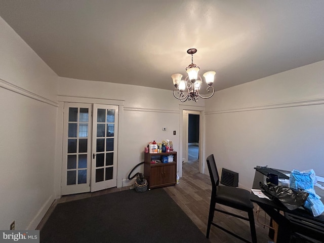 home office with wood-type flooring, french doors, and a chandelier