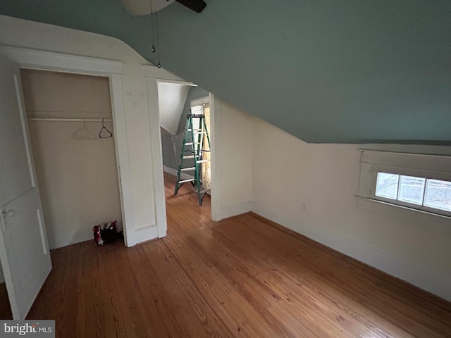 additional living space featuring hardwood / wood-style flooring, ceiling fan, and lofted ceiling