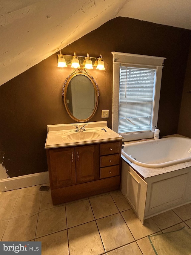 bathroom with tile patterned floors, a bathing tub, vanity, and vaulted ceiling