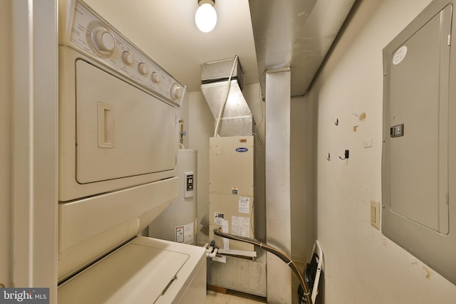 clothes washing area featuring stacked washer / dryer, electric panel, and water heater