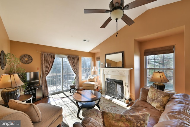 living room featuring a premium fireplace, ceiling fan, plenty of natural light, and lofted ceiling