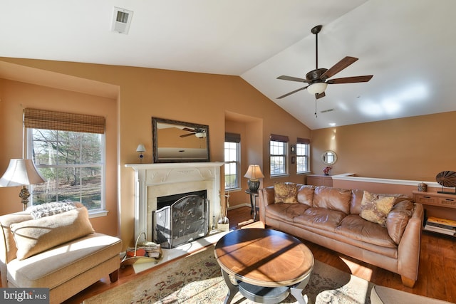 living room featuring lofted ceiling, wood-type flooring, ceiling fan, and a fireplace