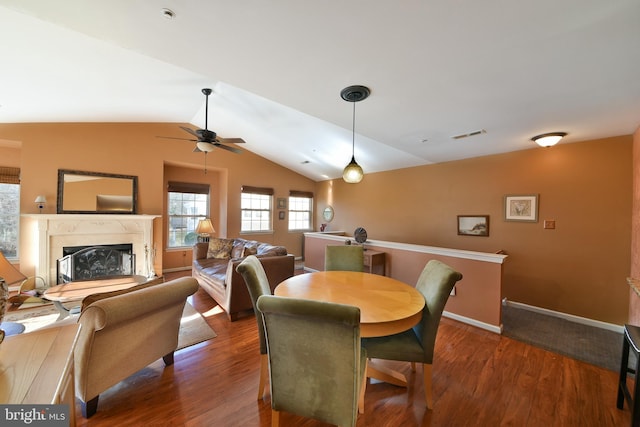 dining area featuring dark wood-type flooring, ceiling fan, and vaulted ceiling