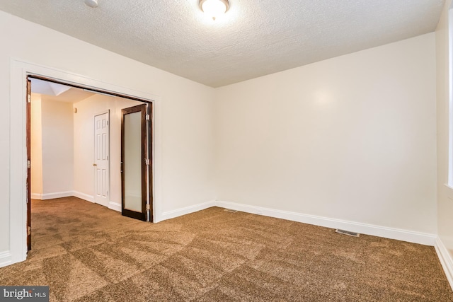 carpeted spare room with a textured ceiling