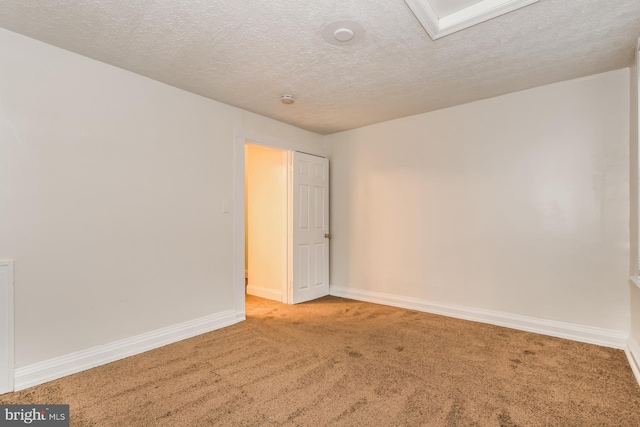 empty room with carpet flooring and a textured ceiling