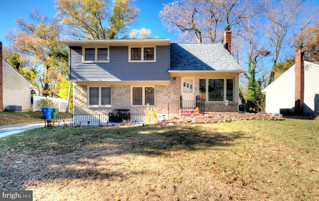 tri-level home with central AC unit and a front yard