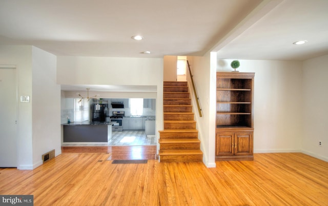 stairs featuring hardwood / wood-style floors