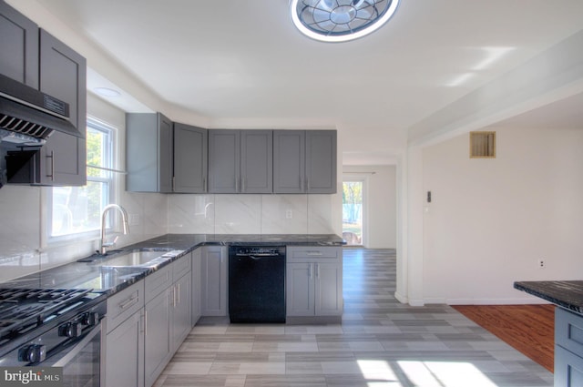 kitchen with a healthy amount of sunlight, sink, light hardwood / wood-style flooring, and dishwasher