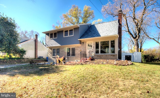 view of front of house with central air condition unit and a front lawn