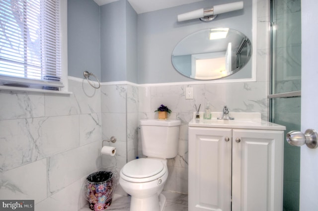 bathroom with vanity, toilet, and tile walls