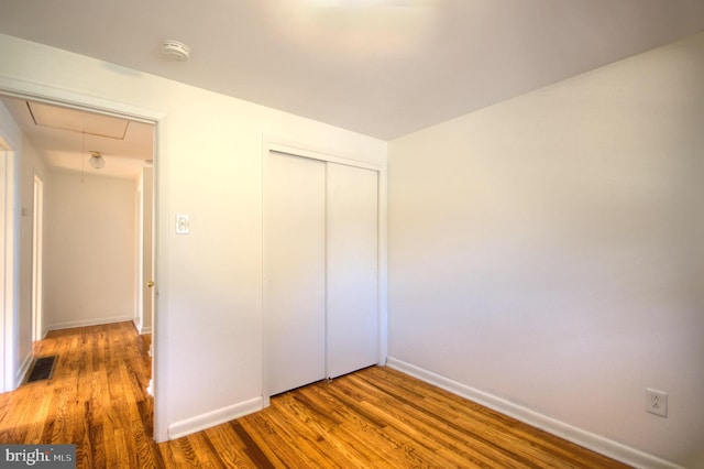 unfurnished bedroom featuring hardwood / wood-style flooring and a closet