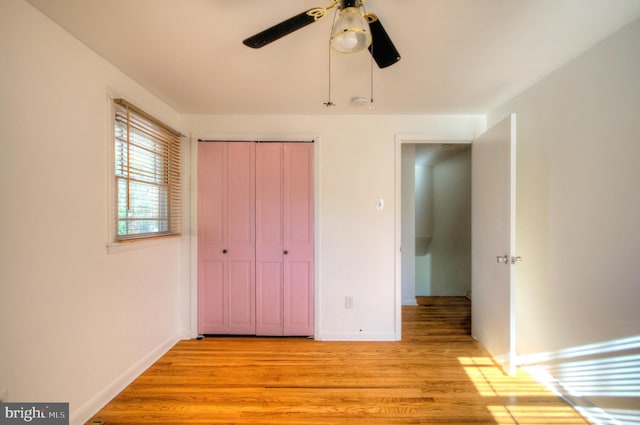 unfurnished bedroom featuring light hardwood / wood-style floors, ceiling fan, and a closet