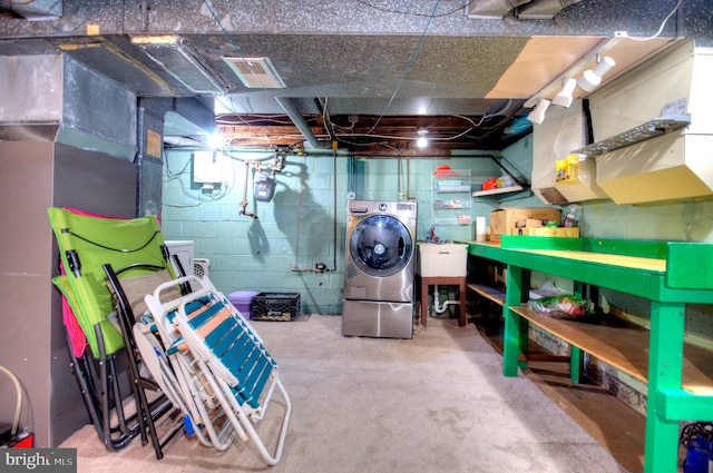 basement featuring sink and washer / dryer