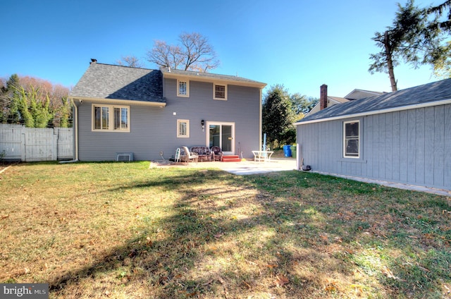 rear view of property with a lawn and a patio area