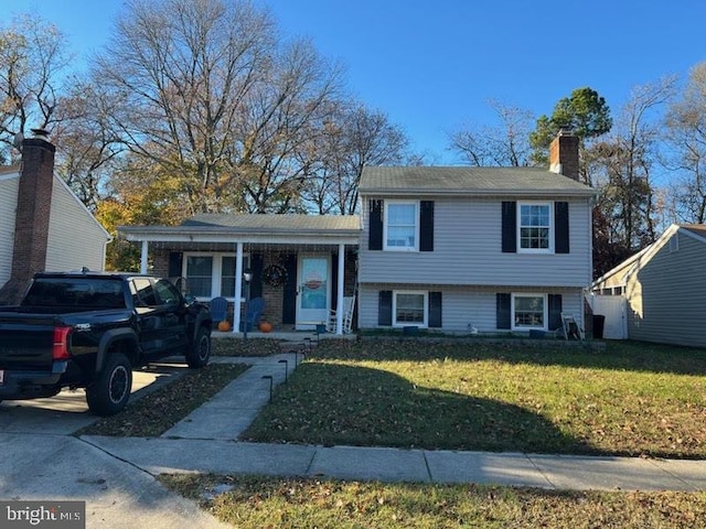 tri-level home with a porch and a front lawn