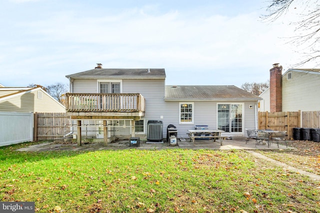 back of property with a deck, central AC, a patio area, and a lawn