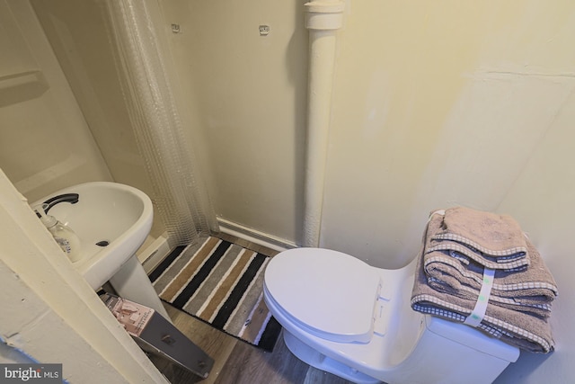 bathroom with toilet and hardwood / wood-style flooring