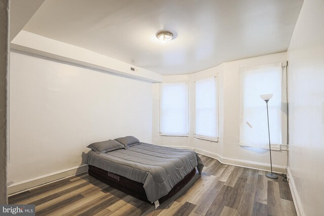 bedroom with dark hardwood / wood-style flooring