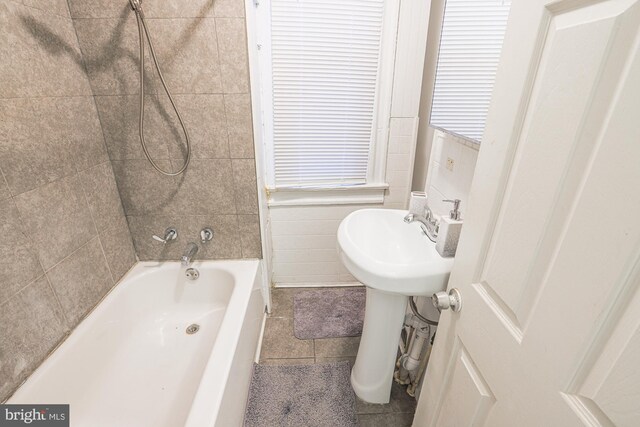 bathroom featuring tile walls, tiled shower / bath, and tile patterned floors