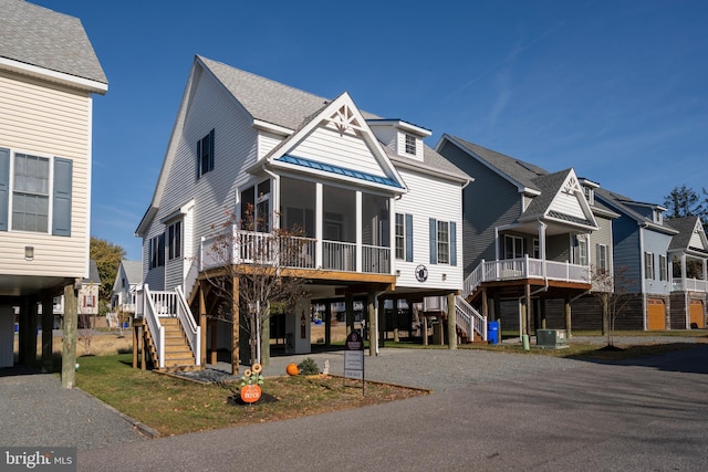 coastal home with a carport, a sunroom, and cooling unit