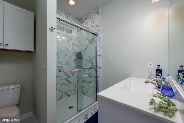 bathroom with vanity, toilet, and a shower with shower door