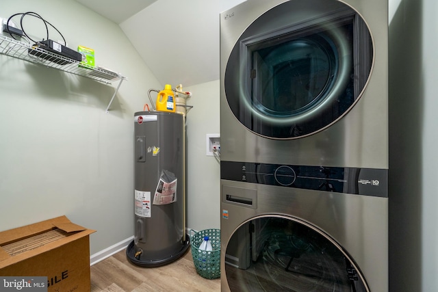 washroom with stacked washing maching and dryer, wood-type flooring, and electric water heater