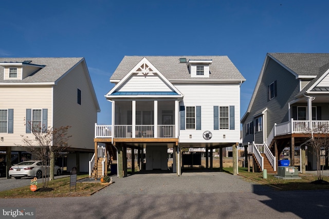 coastal inspired home featuring a carport, cooling unit, and a sunroom