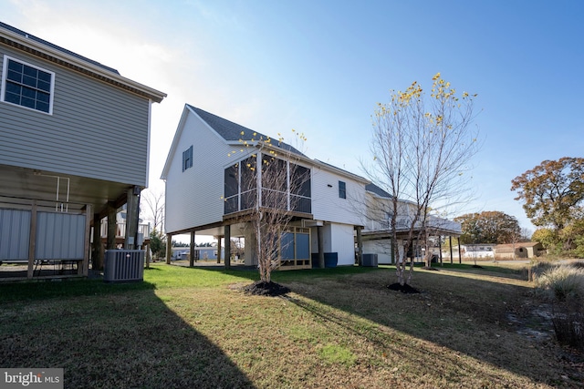 rear view of house with a yard and central AC unit