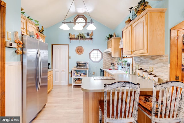 kitchen featuring light hardwood / wood-style floors, kitchen peninsula, appliances with stainless steel finishes, light brown cabinetry, and decorative light fixtures